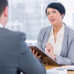 Un recruteur échange avec une candidate lors d’un entretien d’embauche dans un bureau.